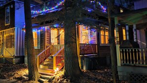 A two-story house with a covered porch and a staircase leading to the upper level. - Delightful cottage in charming Mount Gretna in an amazing location! (Mount Gretna)
