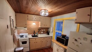 A kitchen with wooden cabinets, a stove, a sink, and a refrigerator. - Delightful cottage in charming Mount Gretna in an amazing location! (Mount Gretna)