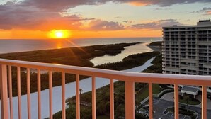 A sunset view from a balcony overlooking a river and a building. - Gorgeous 17th fl sunsets @ South Seas 2BR/2BA NEW mattresses updated furnishings (Marco Island)