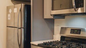 Uma cozinha com eletrodomésticos de aço inoxidável, incluindo geladeira, micro-ondas e fogão.