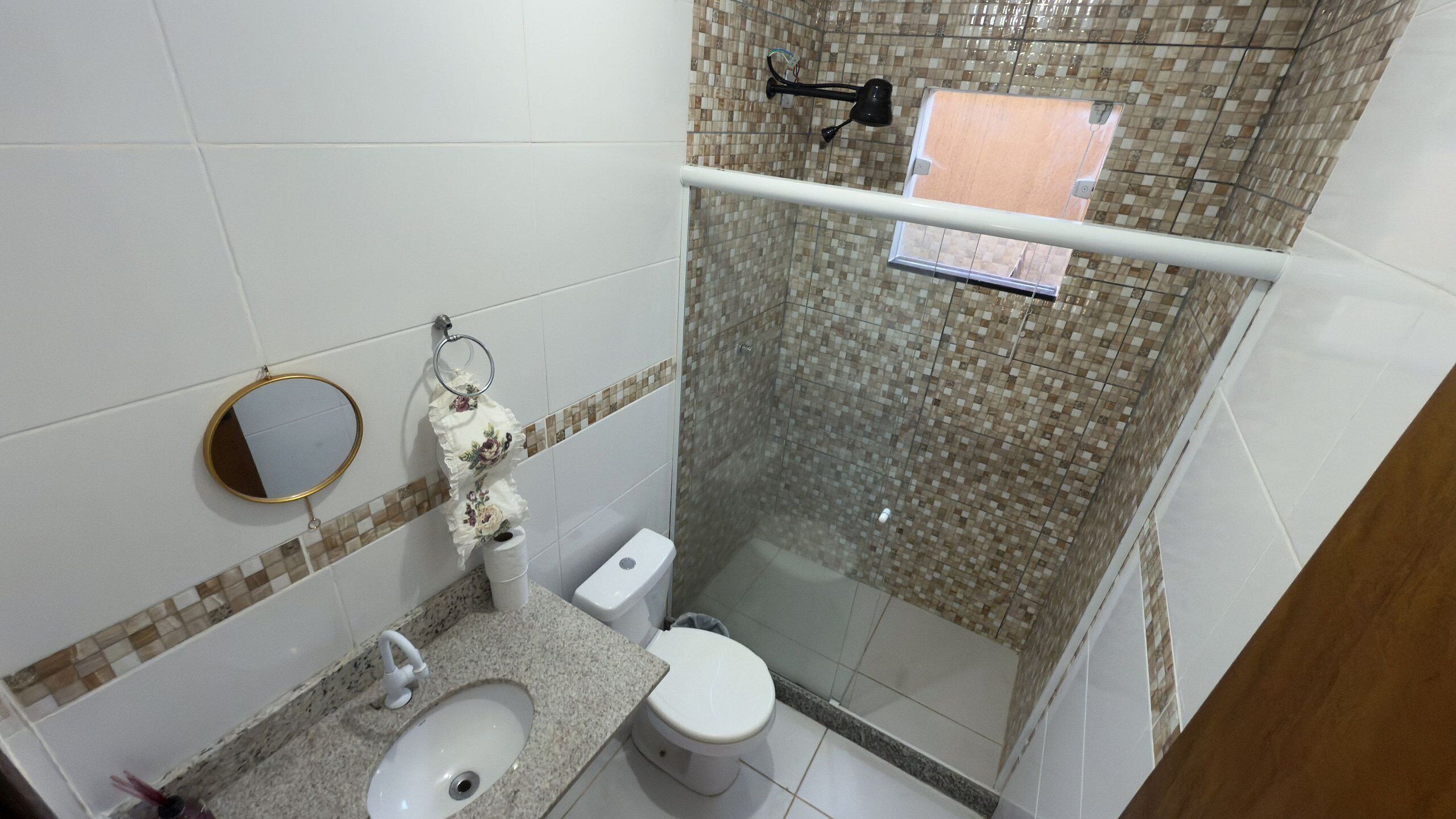 Une salle de bain comprenant des toilettes, un lavabo et un espace douche.