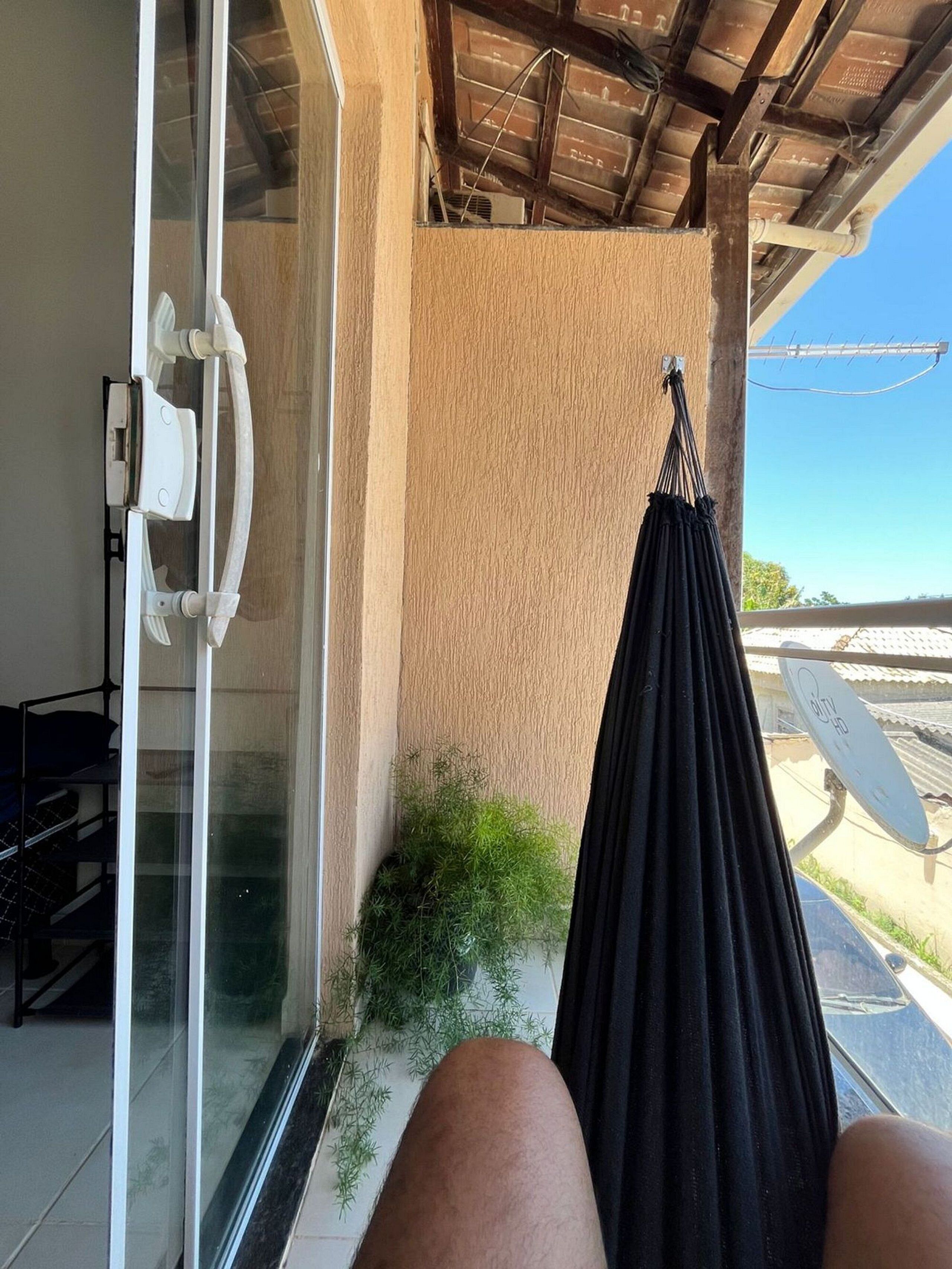 A room with a glass door, a hammock, and a satellite dish.