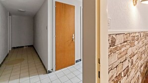 A hallway with a wooden door, white walls, and a tiled floor. - Crans-Montana - Studio 2 pp - Centre/Rue du Prado (Lens)