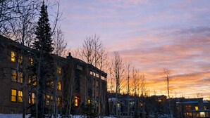 A snow-covered landscape with buildings and bare trees during sunset. - Cozy condo with Pool, Jacuzzi, Sauna, & Fitness Center. Minutes to either lift! (Brian Head)