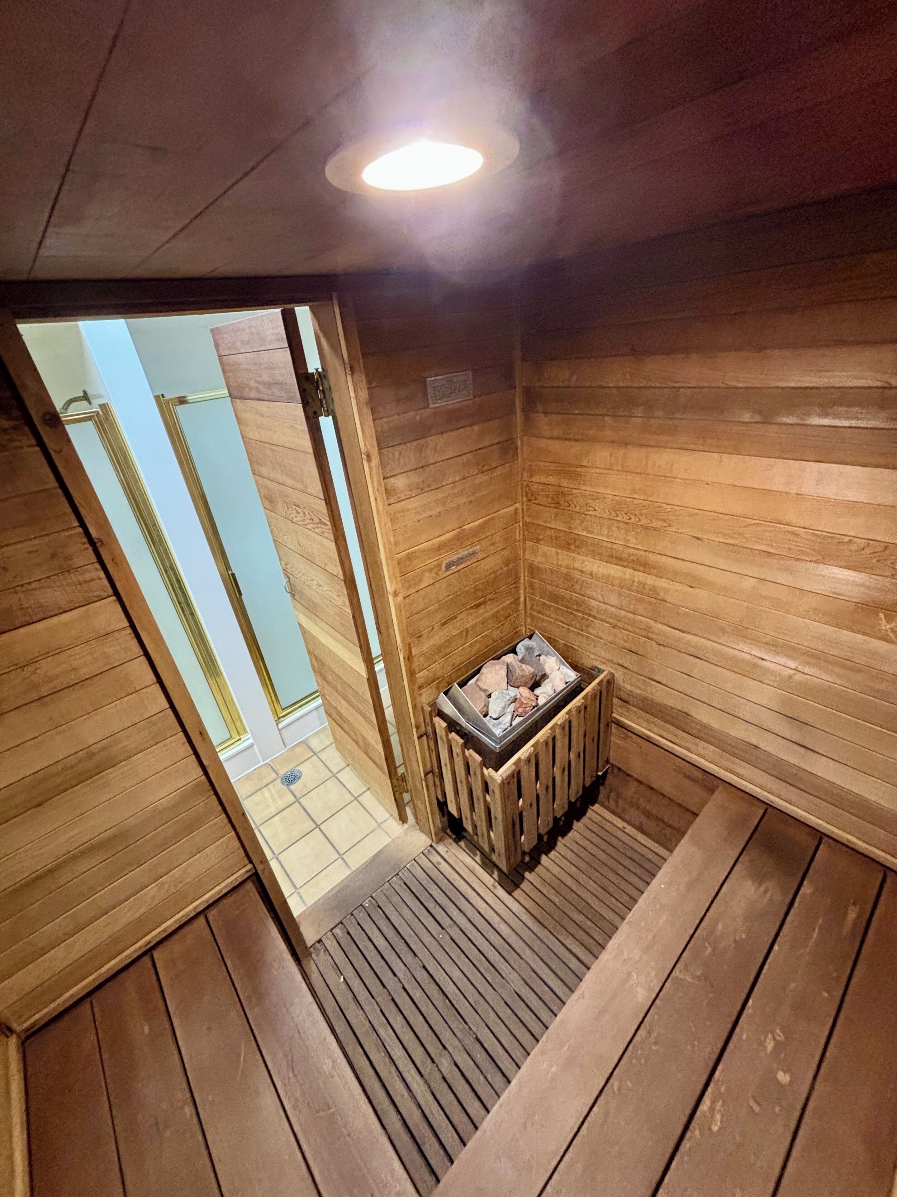 Een sauna met houten wanden en een bank met stenen.