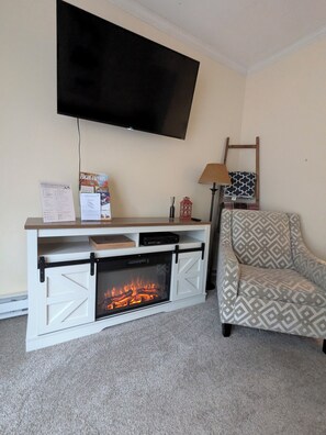 A living room with a fireplace, a television mounted on the wall, a sofa, and a lamp. - 3-bedroom Mountain-Stream Townhome in Banner Elk (Banner Elk)
