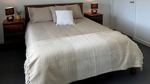 A bedroom with a bed, two bedside tables, a ceiling fan, and a door. - Cosy and comfortable executive Unit with gorgeous views and close to town centre (Clare)
