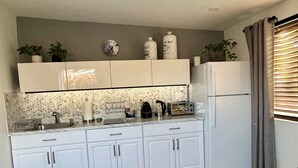 Una cucina moderna con mobili bianchi, piastrelle a mosaico e forno incassato.