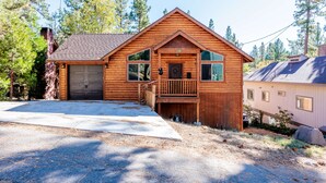 A wooden cabin with a garage, a front porch, and a deck. - Bearadise ~ Enchanted Dream ~ Mountain Escape (Big Bear Lake)