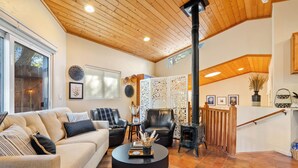 A spacious living room with a high ceiling, a fireplace, and a staircase leading to an upper level. - Private Studio-15 miles to SLO and Paso (Atascadero)