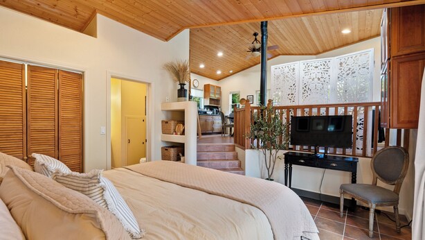 A bedroom with a large bed, wooden ceiling, and a TV in the corner. - Private Studio-15 miles to SLO and Paso (Atascadero)