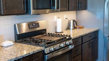 Une cuisine équipée d’une cuisinière, d’un four à micro-ondes et d’un réfrigérateur en acier inoxydable.