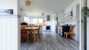 Une cuisine spacieuse dotée d’un plancher en bois, de meubles blancs et d’un îlot central.
