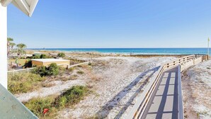 A beach view with a wooden boardwalk leading to the ocean. - Seaside Sanctuary • 2 Min Walk to Okaloosa Beach (Fort Walton Beach)