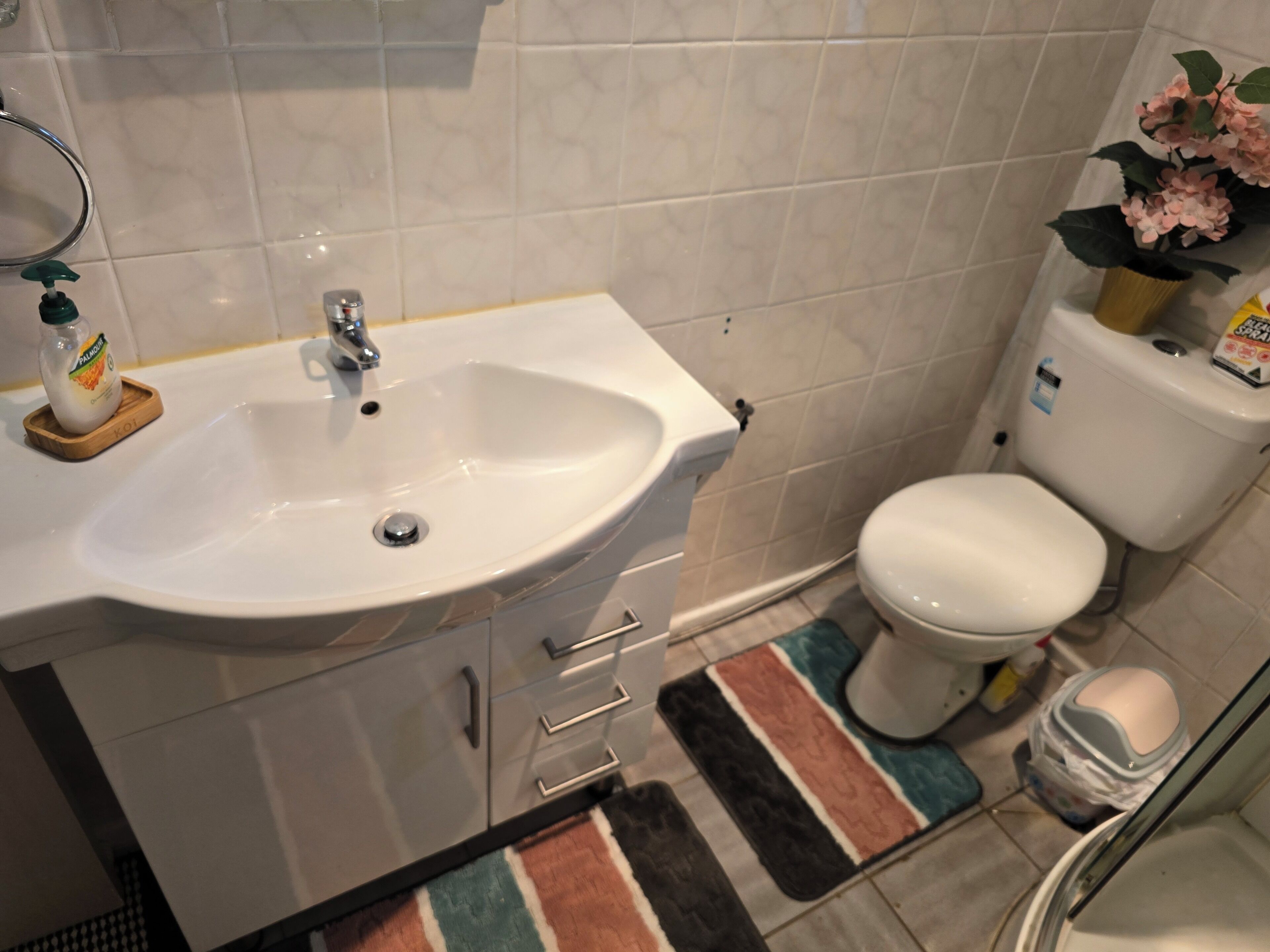 Un baño con lavamanos blanco, inodoro y zona de ducha.