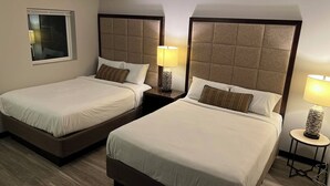 Two twin beds with headboards, bedside tables with lamps, and a window with blinds. - Your home away from home (Rocky Mount)