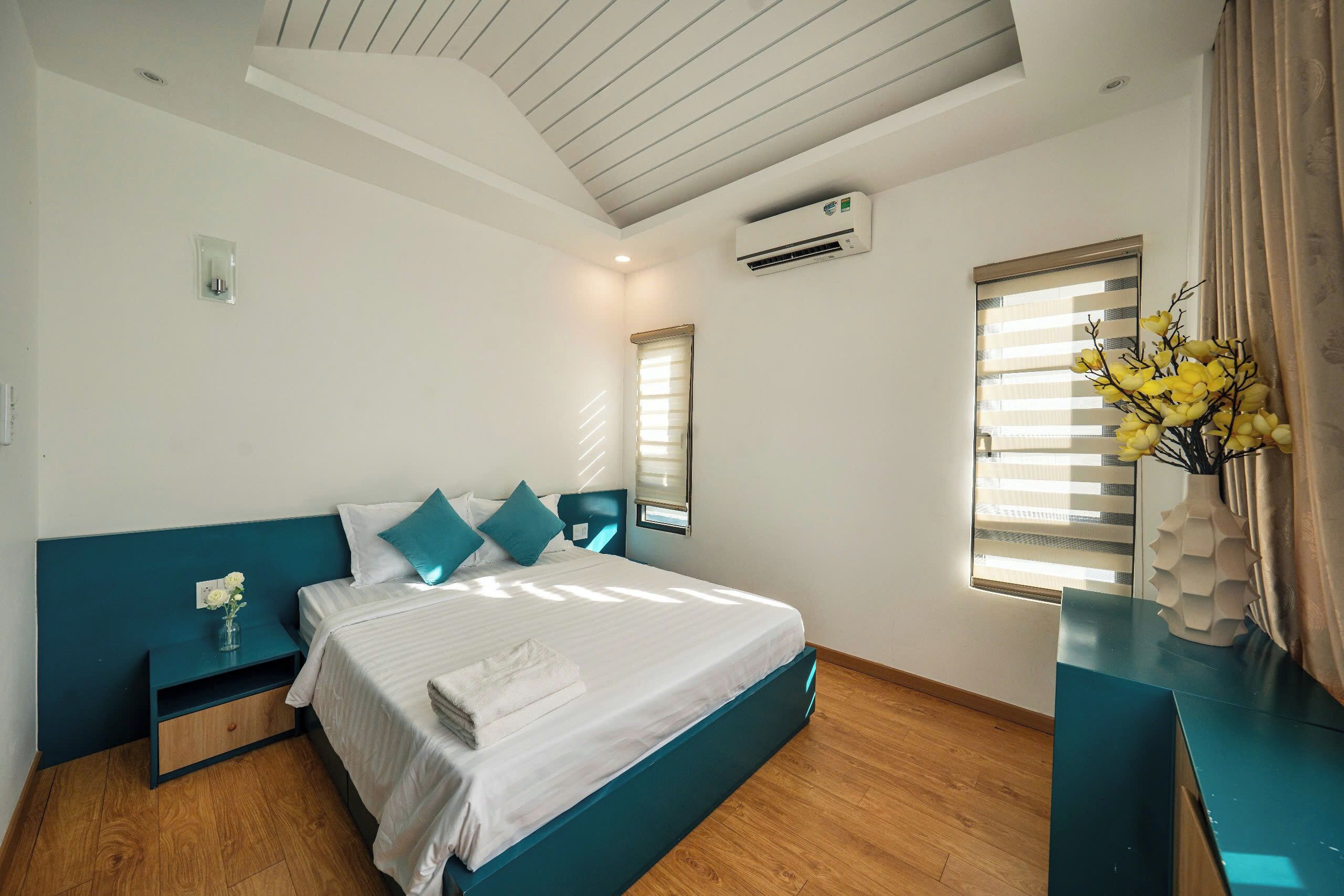 A modern bedroom with a bed, bedside table, and a nightstand.