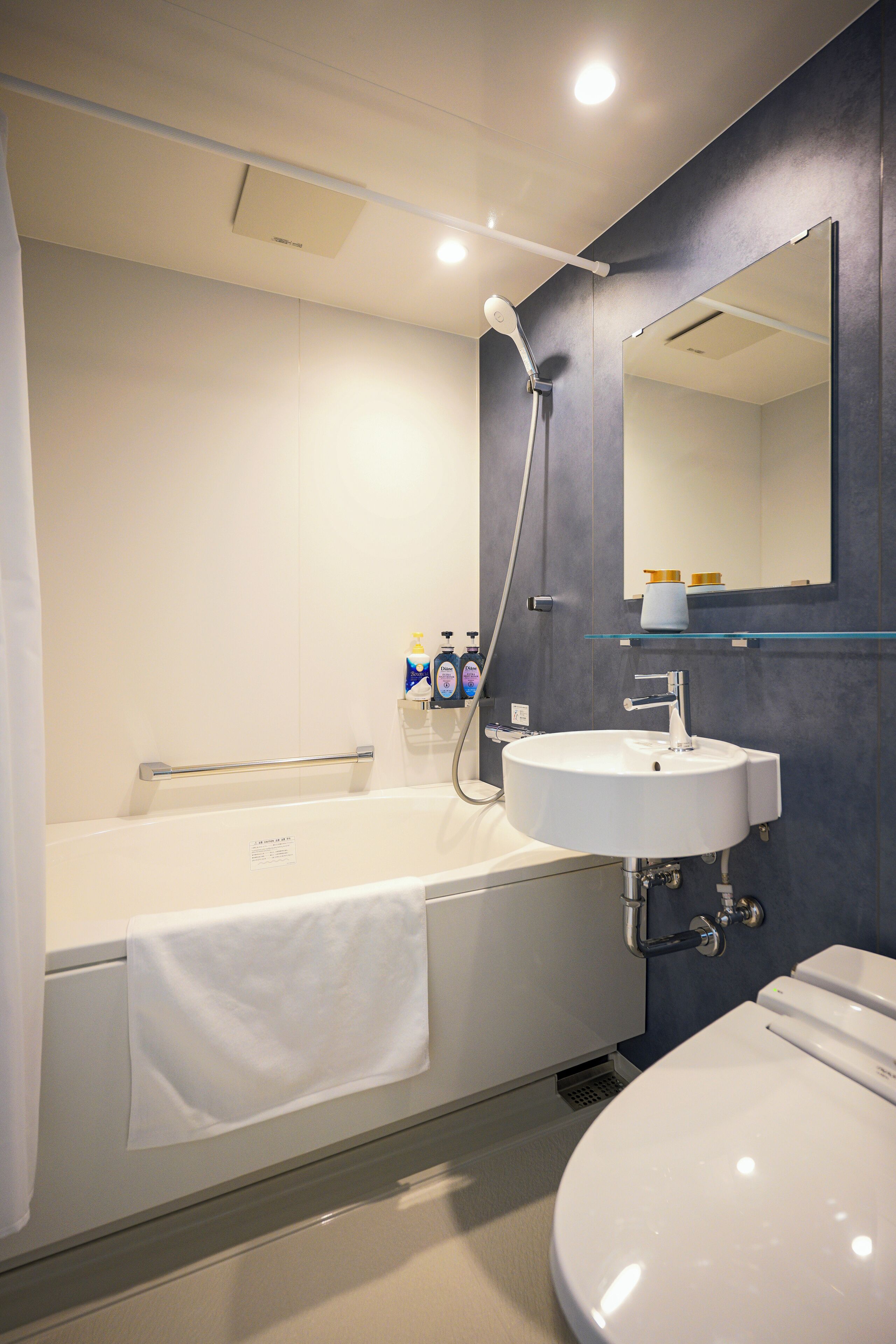 A modern bathroom with a bathtub, a sink, and a toilet.