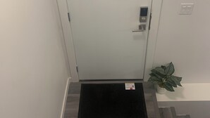 A white door with a small window, a metal handle, and a keyhole. - Friendly extended stay and comfort (Winnipeg)
