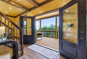 A wooden interior with a staircase leading to a balcony. - Velare at Whispering Ridge | Luxury Shenandoah Cabin | Hot Tub, Game Room, Gym (Stanley)