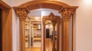 A hallway with ornate wooden columns and a large mirror. - Tyms Xujiahui Premium 2BR APT Metro (Shanghai)