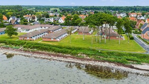 A residential area with houses, a grassy field, and a body of water.