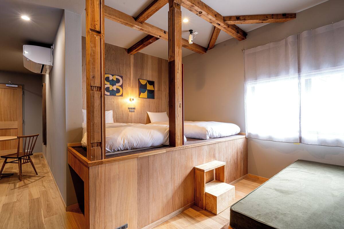 Una habitación pequeña con una cama de madera, un escritorio y una silla.