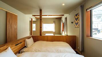 A hotel room with a wooden headboard, a large bed, a window with curtains, and a view of the outside.