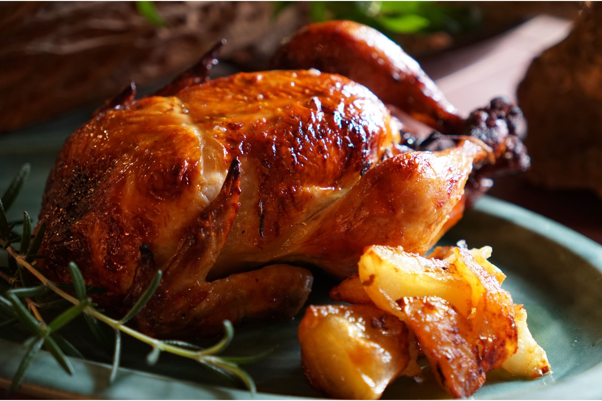 Pollo asado con patatas en un plato.
