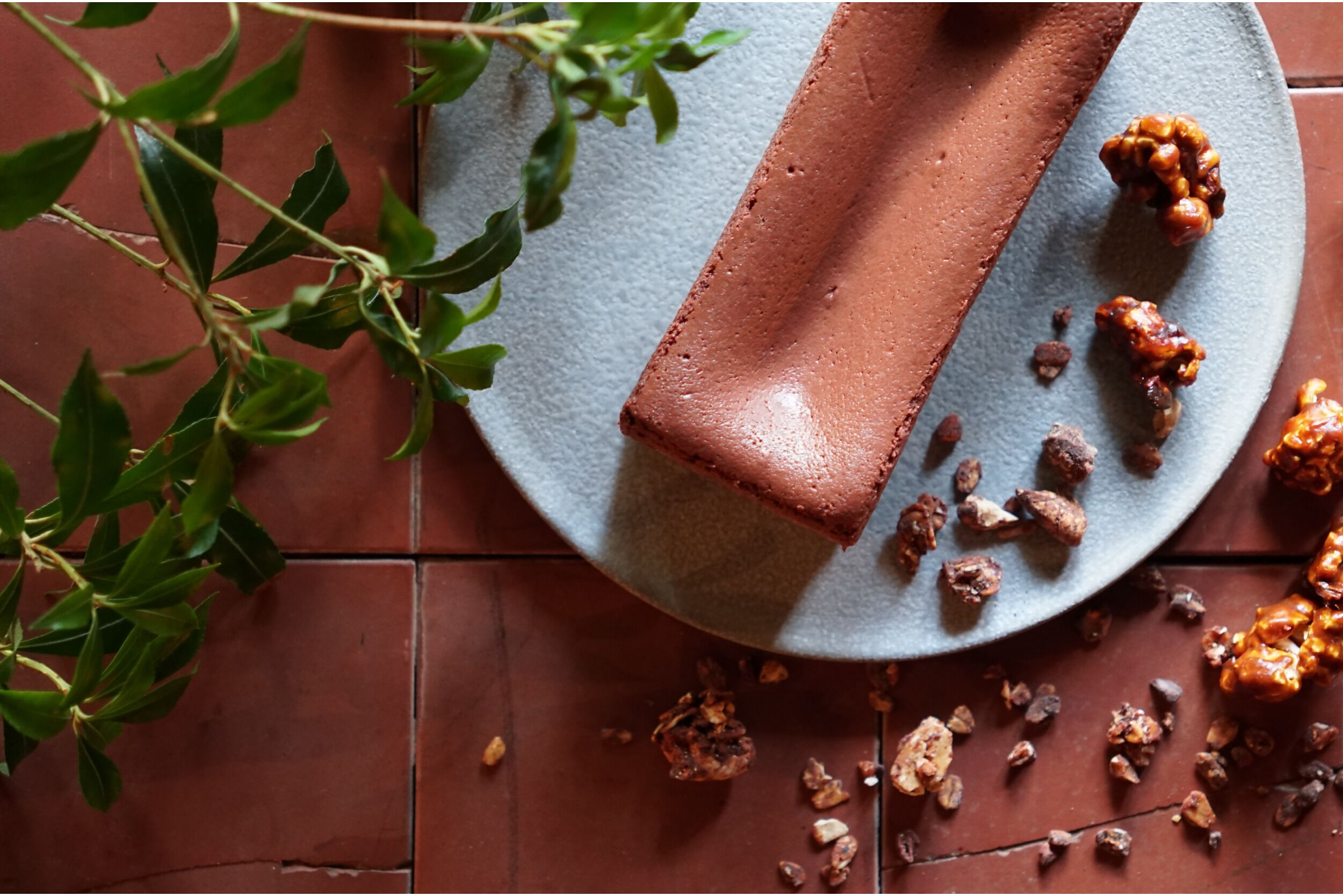 A round table with a chocolate bar and scattered nuts.
