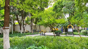 A park with exercise equipment, a bench, and a signboard. - Tyms Xujiahui Elegant 1BR APT  (Shanghai)