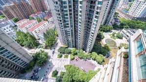 A high-rise residential building with multiple balconies, a central courtyard, and surrounding greenery. - Tyms Xujiahui Elegant 1BR APT  (Shanghai)