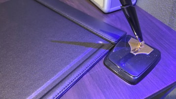 A close-up of a metallic object with a reflective surface, possibly a tool or part of a device, on a purple surface.