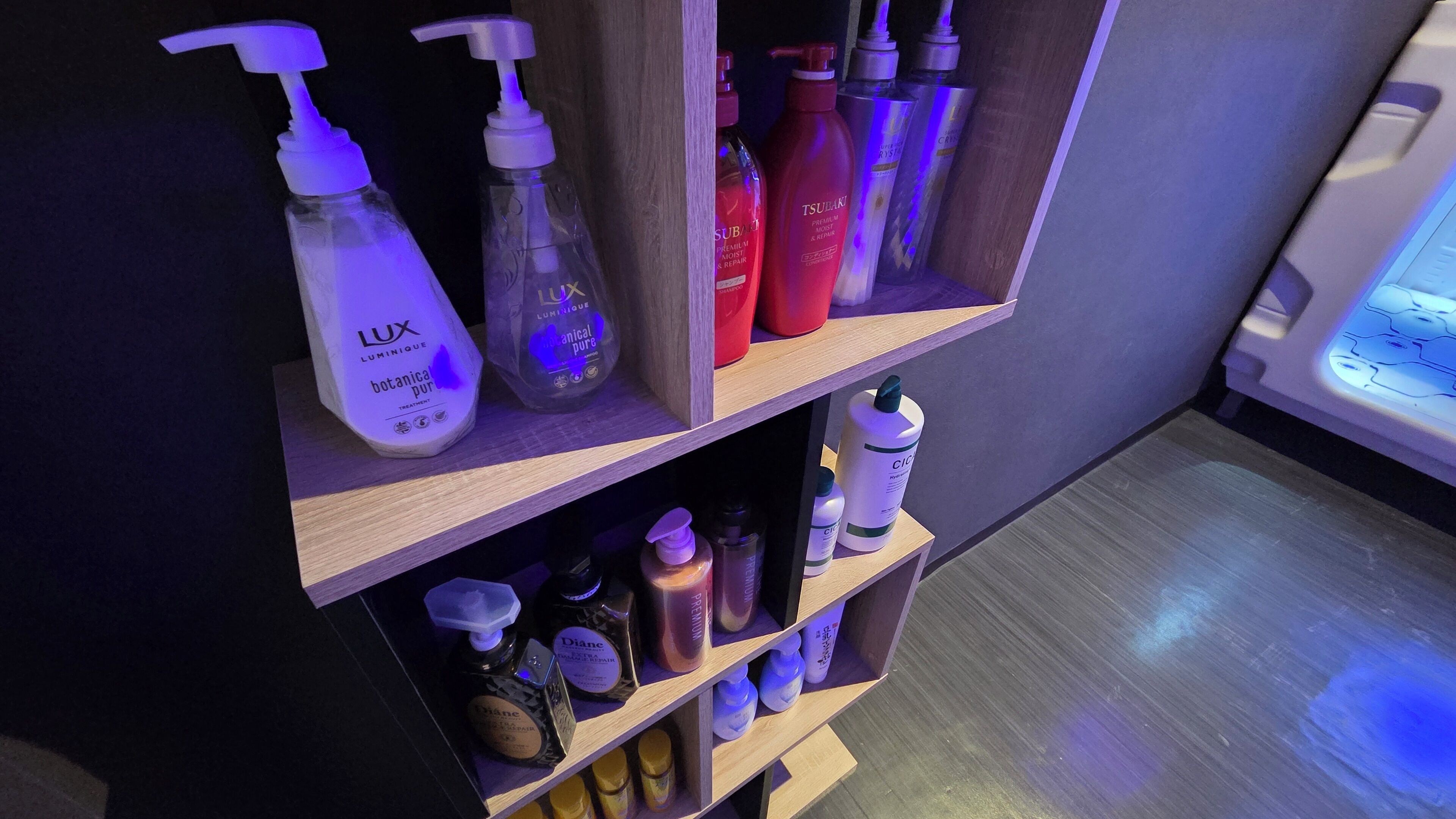 A shelf with various toiletries including bottles of shampoo, conditioner, and body wash.