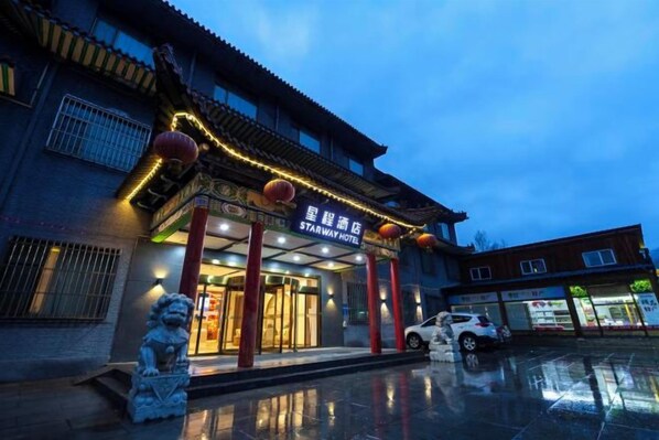 A hotel entrance with traditional architecture, a signboard, and a statue. - Starway Hotel (Wutai Mountain) (Wutai)