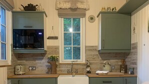 Una cucina accogliente con soffitto in legno, una finestra vista e un lavello.