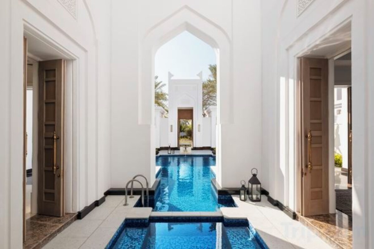 A pool area with a clear view of the pool, surrounded by white walls and doors.