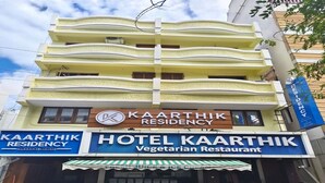 Ein Gebäude mit einem Schild für 'Kaarthik Residency' und 'Hotel Kaarthik Vegetarisches Restaurant'.