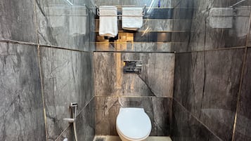 Habitación estándar doble | Baño | Ducha, cabezal de ducha tipo lluvia, toallas y jabón