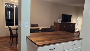 A modern kitchen with a wooden countertop, white cabinetry, and a built-in oven. - Downtown Chanhassen Townhome - 3 bedrooms (Chanhassen)