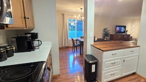 A compact kitchen with a coffee maker, a trash bin, and a wooden countertop. - Downtown Chanhassen Townhome - 3 bedrooms (Chanhassen)