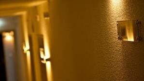 En hall med en väggmonterad lampa och en dörr längst ner.