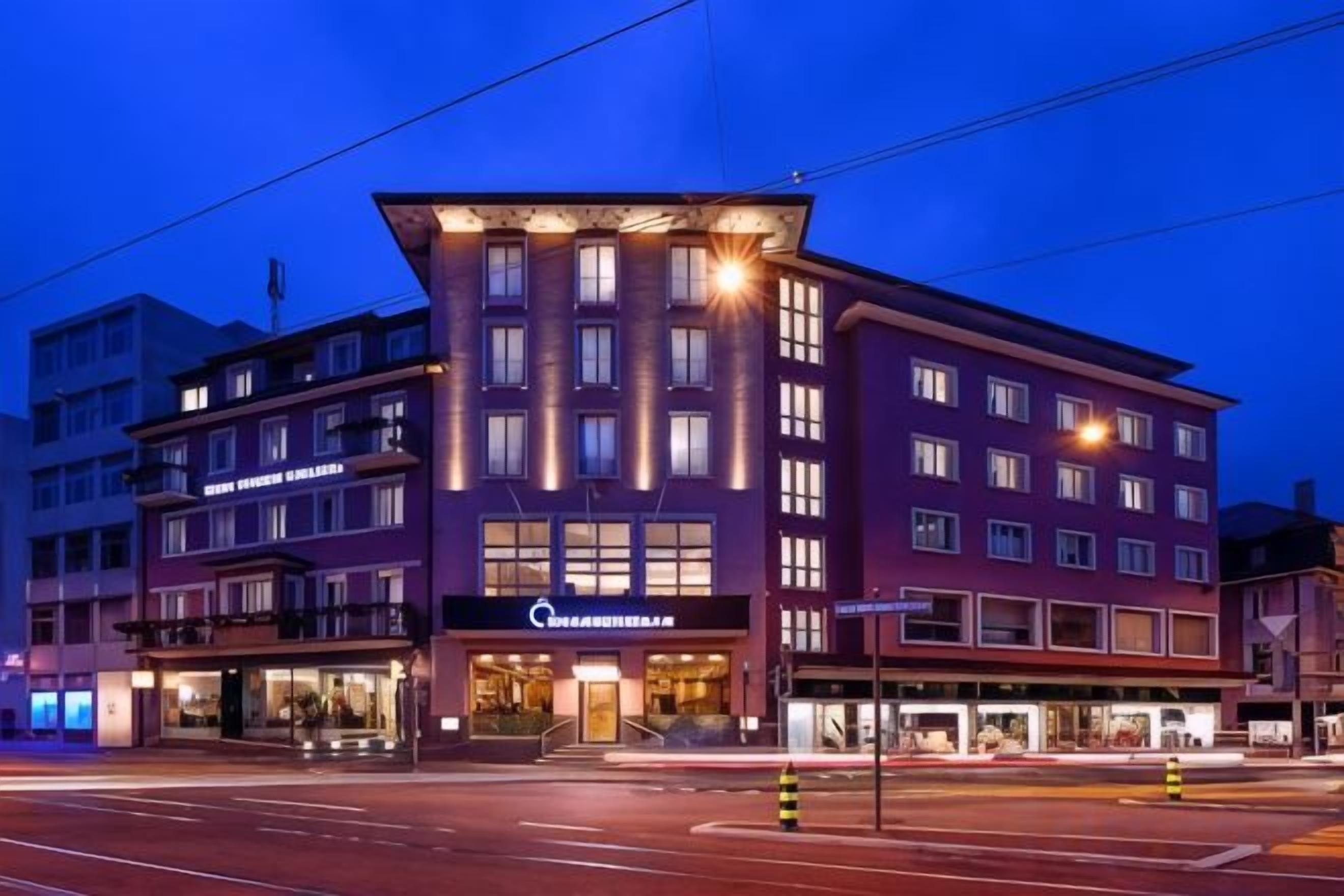 Ein mehrstöckiges Hotel mit einem markanten Eingang und einem sichtbaren Restaurantschild.
