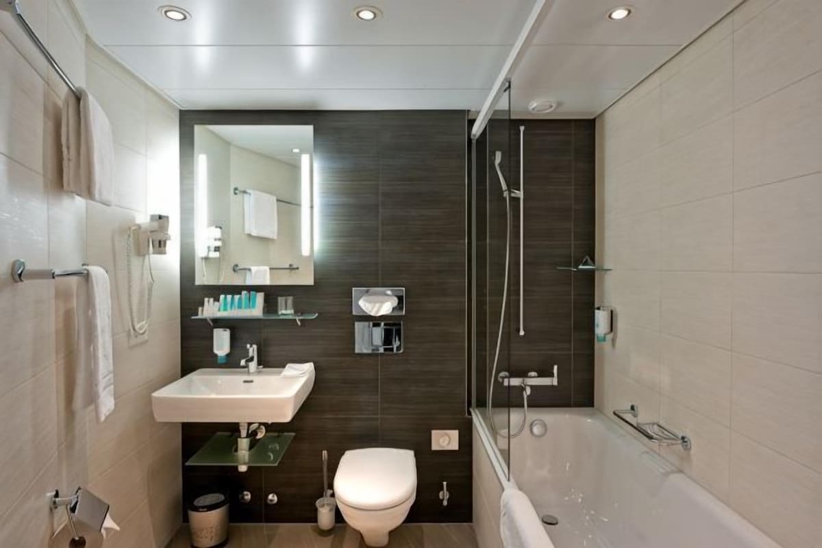 Une salle de bain moderne équipée d’un lavabo, de toilettes et d’une douche.
