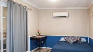 A bedroom with a bed, a desk, and an air conditioning unit. - Casa Sol, centrally located in Bullhead City, Az (Bullhead City)