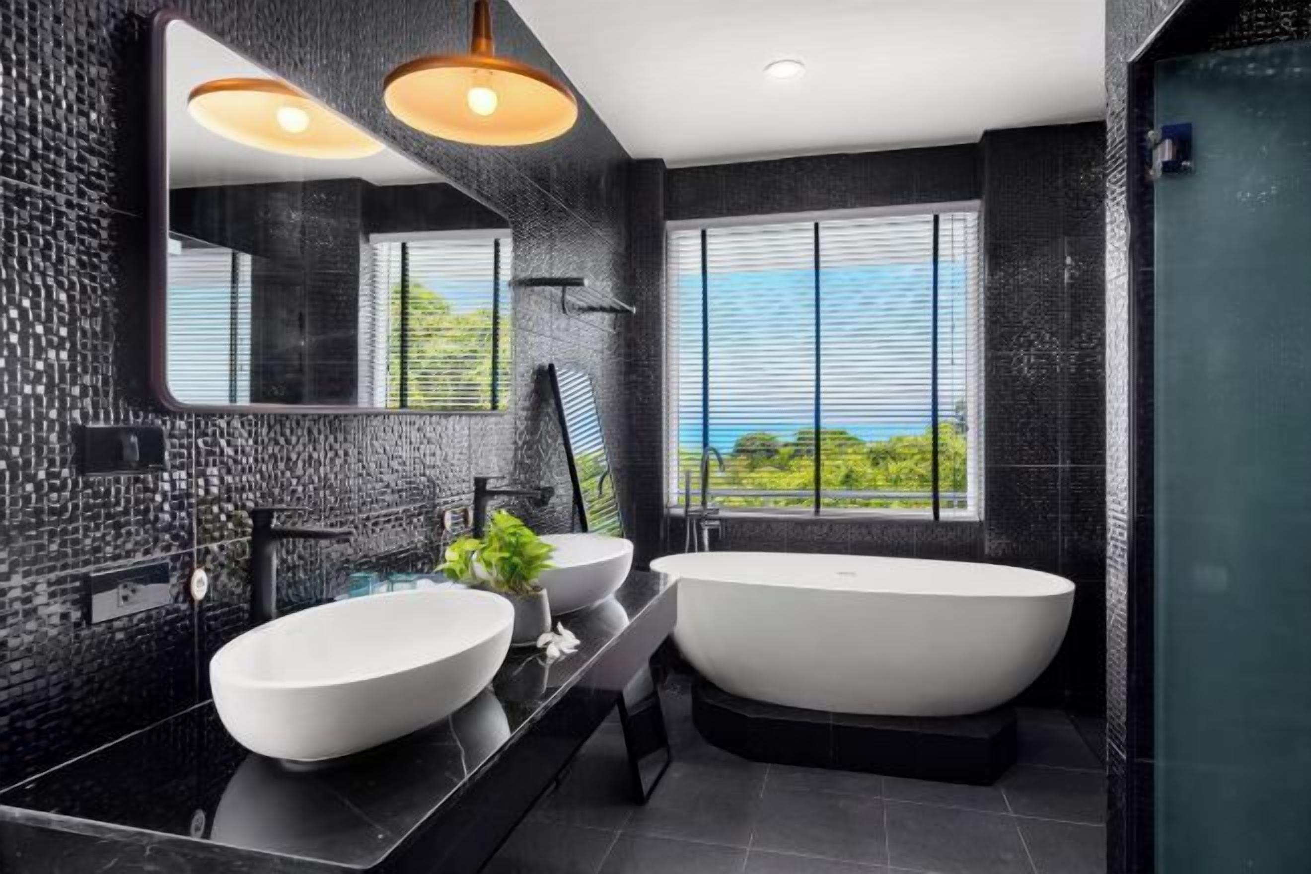 A modern bathroom with a large bathtub, two sinks, a large mirror, and a view of greenery through the window.