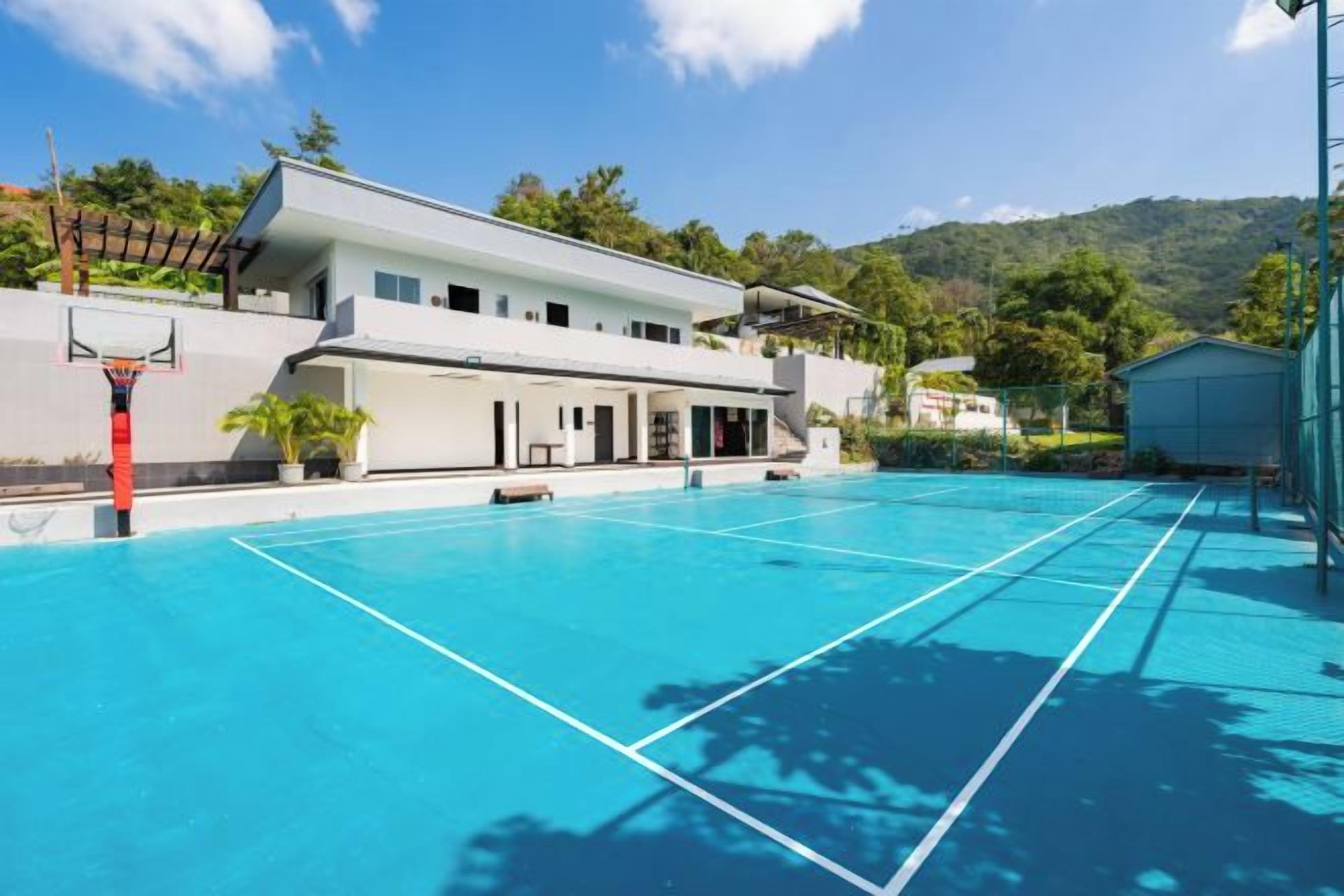 A modern building with a basketball court, a tennis court, and a pool.