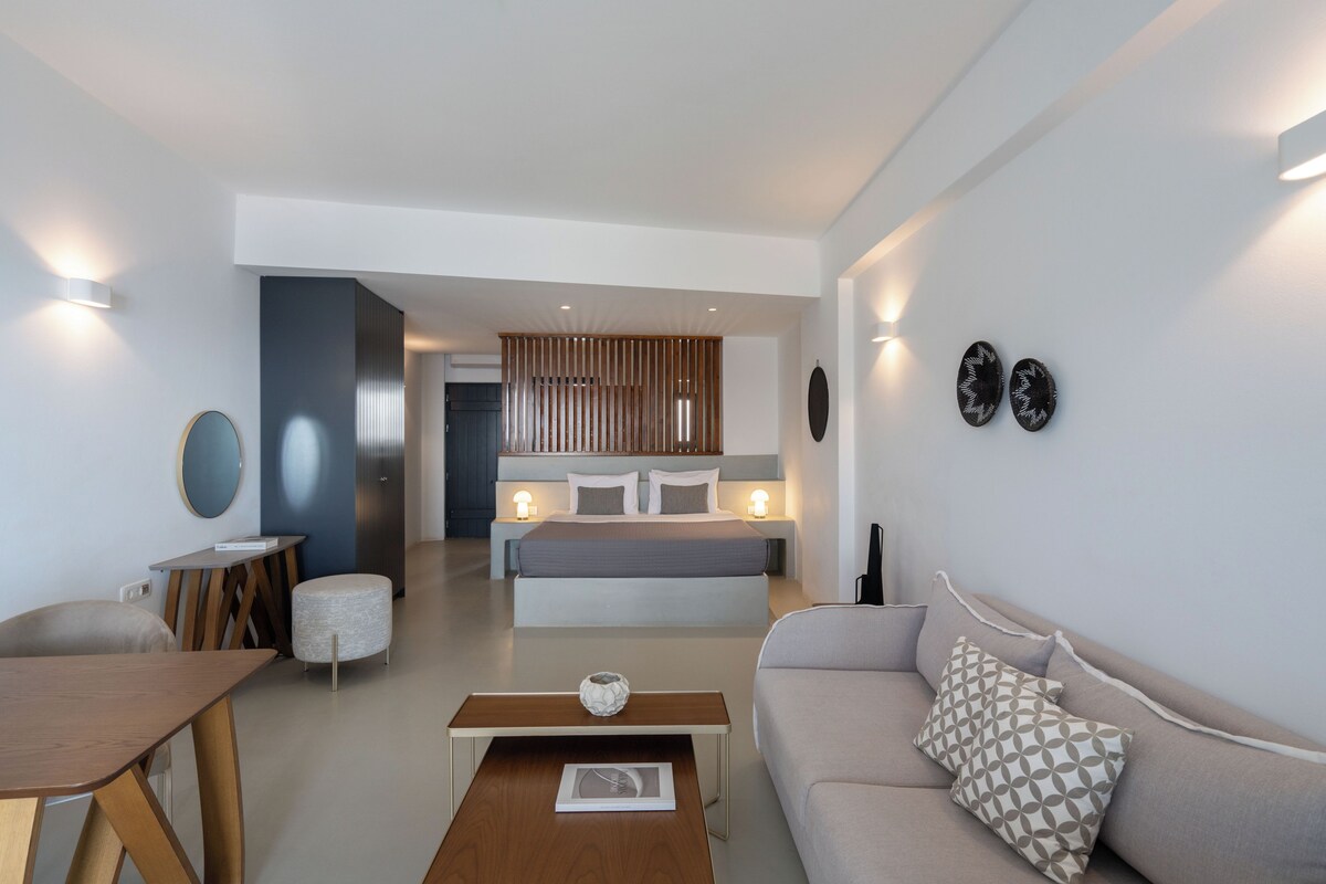 Una sala de estar moderna con sofá, mesa de centro y comedor.