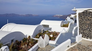 Un bâtiment blanc avec un mur en pierre et une vue sur la mer.