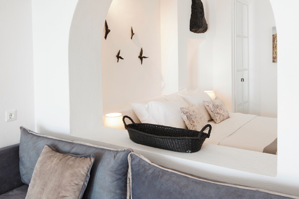 Una habitación moderna con sofá, cama y una ventana de arco distintivo.